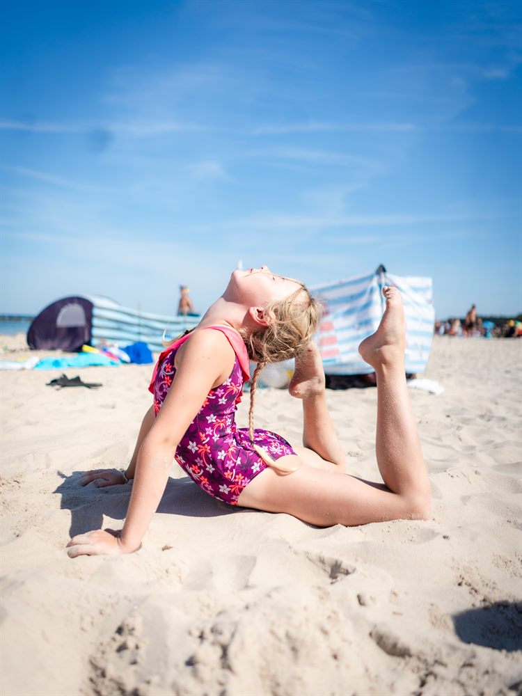 Dziewczynka w figurze akrobatycznej na plaży